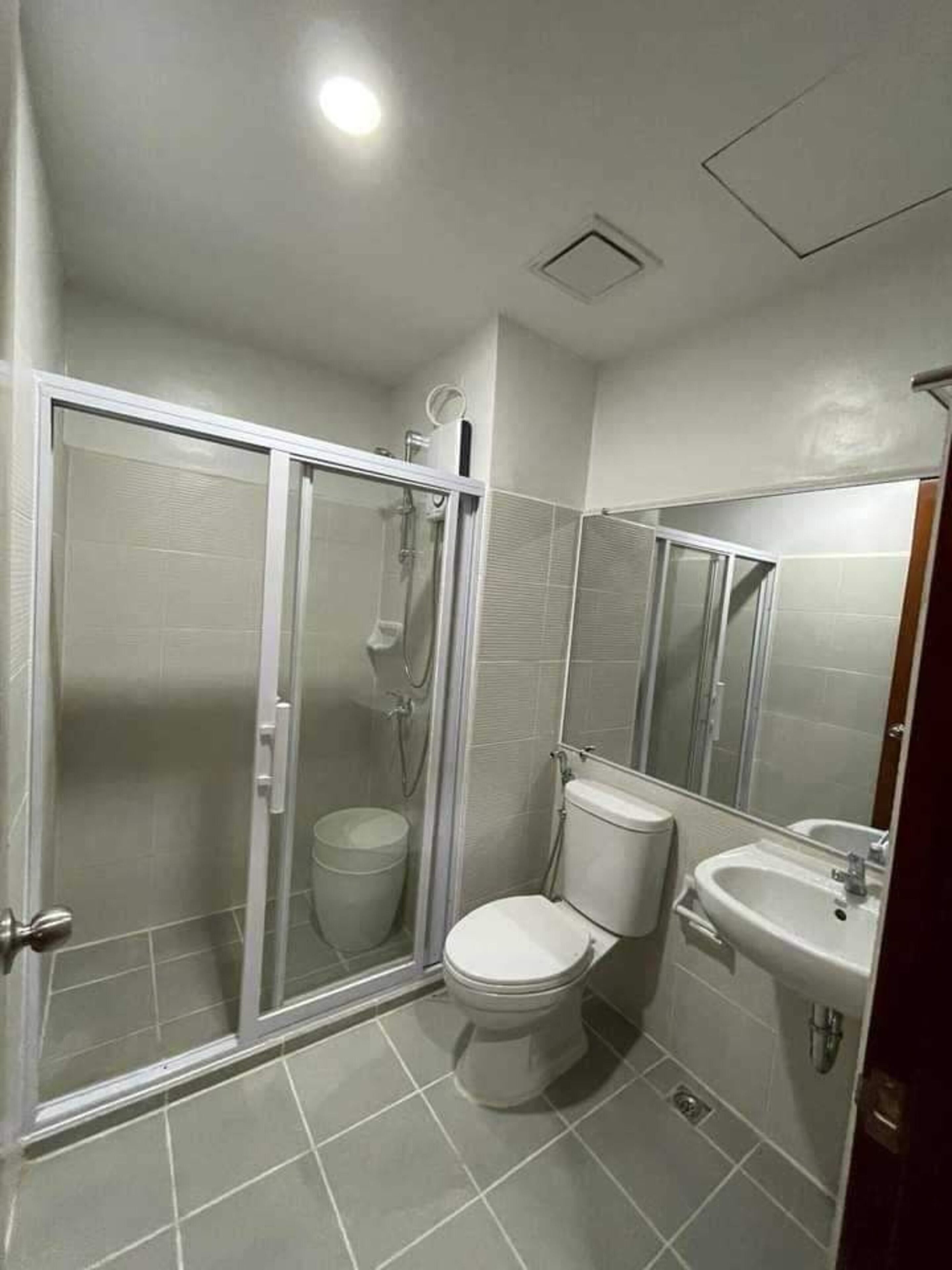 Ein Badezimmer mit einer Duschkabine, einer Toilette und einem Waschbecken.