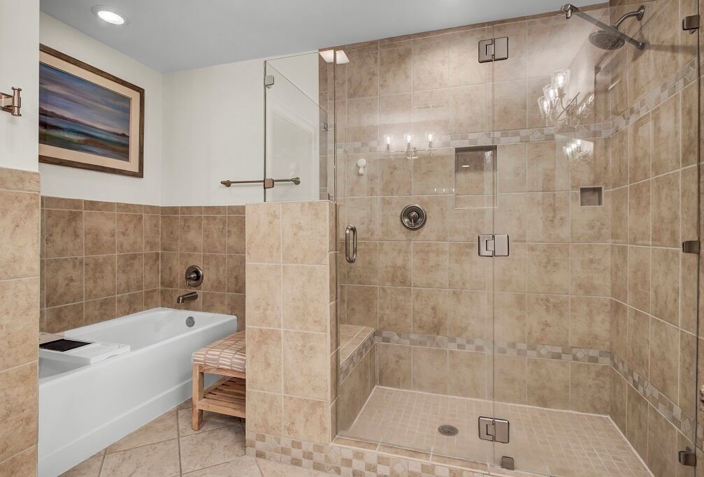 A modern bathroom with a bathtub, shower, and walk-in shower area.
