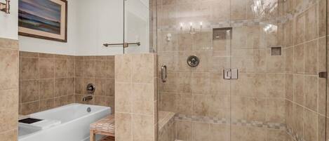 A modern bathroom with a bathtub, shower, and walk-in shower area.