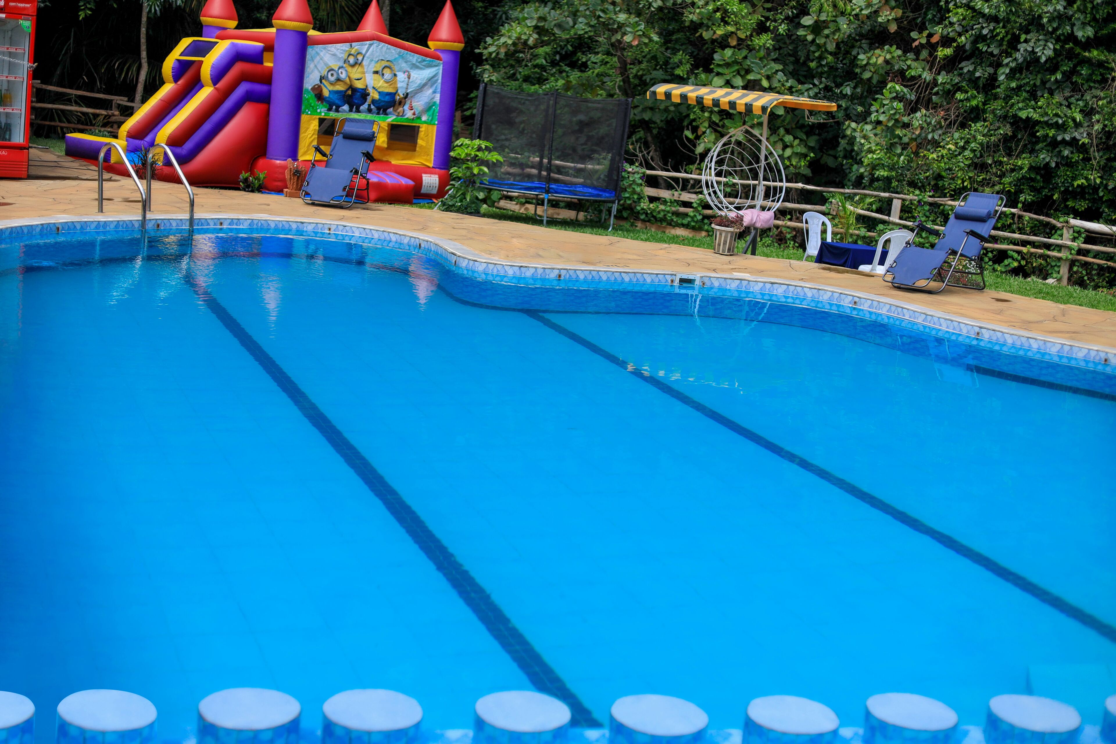 Ein Schwimmbecken mit aufblasbaren Spielgeräten und Liegestühlen.