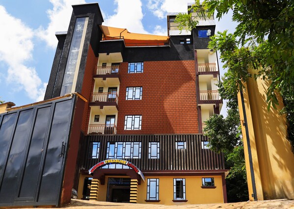 A multi-story building with a prominent entrance labeled "HOPPEEN TREASURE LODGE." - Hidden Treasure Lodge Chuka (Chuka)