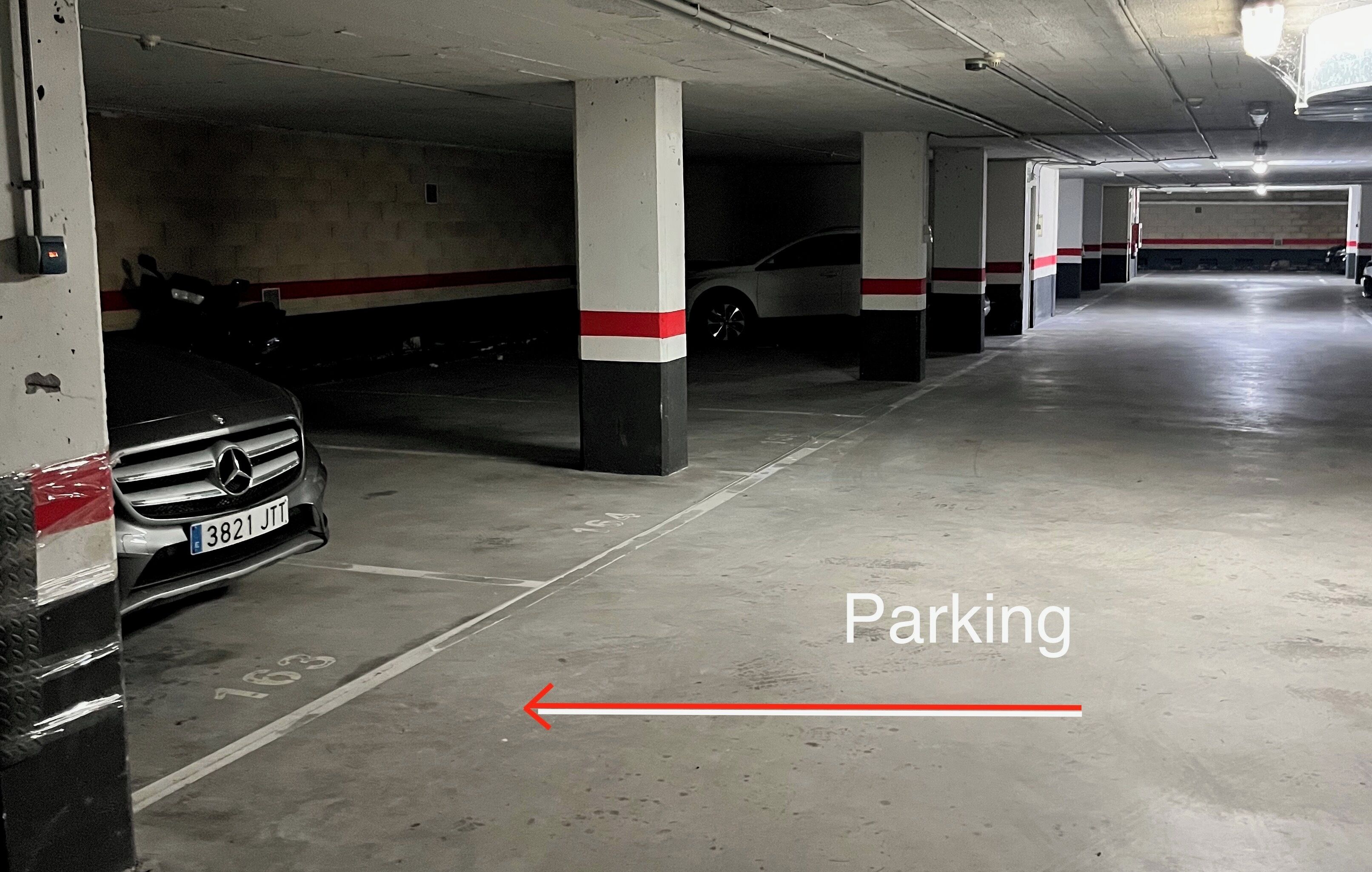 A multi-level parking garage with concrete pillars and white and red stripes.