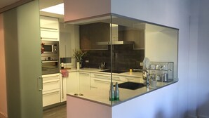 Une cuisine moderne avec des meubles blancs, un plan de travail noir et des appareils électroménagers en acier inoxydable.