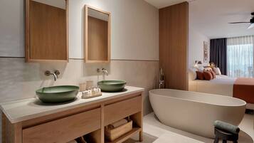 A modern bathroom with two sinks, a freestanding bathtub, and a vanity with storage.