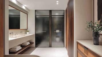 Un baño moderno con una bañera independiente, un espejo grande y una zona de ducha con paredes de cristal.