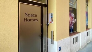Un edificio con una entrada arqueada grande, identificada con el rótulo "Space Homes".