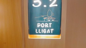 Ein Schild mit der Nummer 3.2 und dem Schriftzug 'PORT LLIGAT' an einer Holztür.
