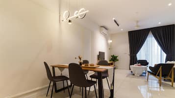 Un comedor moderno con una mesa de madera, sillas oscuras y una lámpara decorativa.
