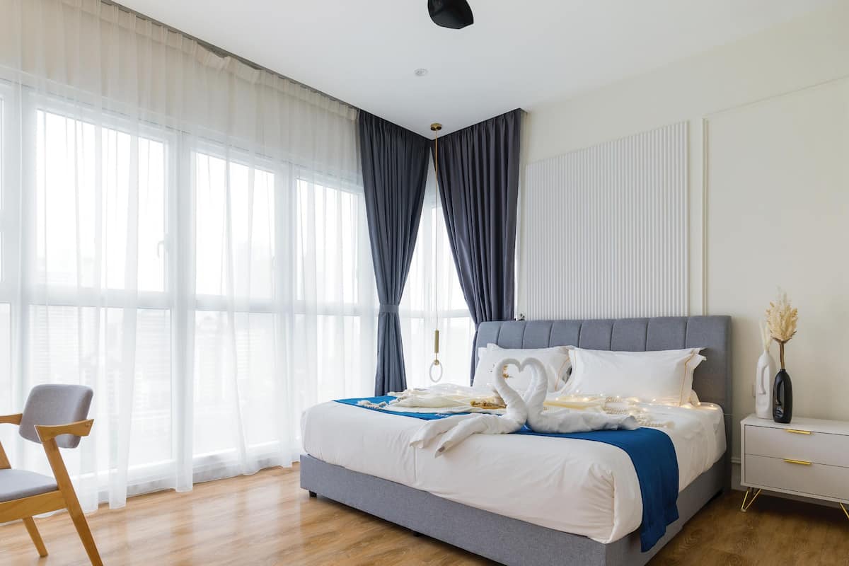 A modern bedroom with a large bed, a desk, and a chair.