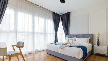 A modern bedroom with a large bed, a desk, and a chair.