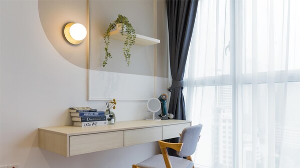 A modern, minimalist room with a built-in desk, a hanging plant, a hairdryer, and a window with sheer curtains. - Quill Residences KLCC, Five Senses (Kuala Lumpur)