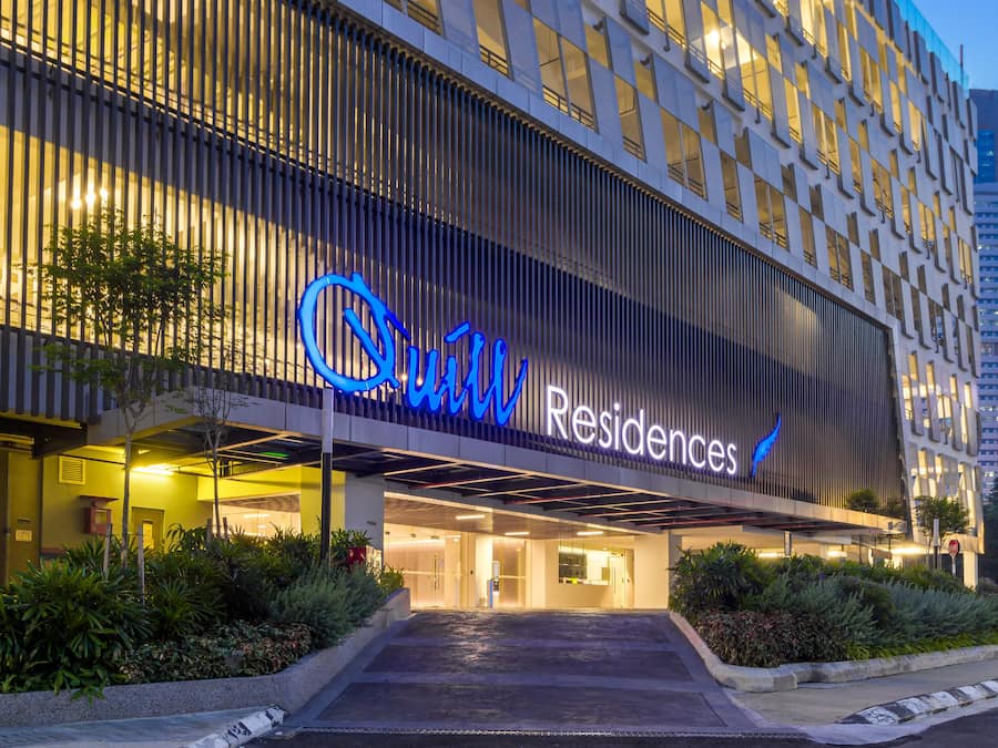A modern building with a sign reading "Quin Residences."