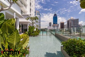 A rooftop pool with a cityscape view, surrounded by lush greenery and modern architecture. - Quill Residences KLCC, Five Senses (Kuala Lumpur)