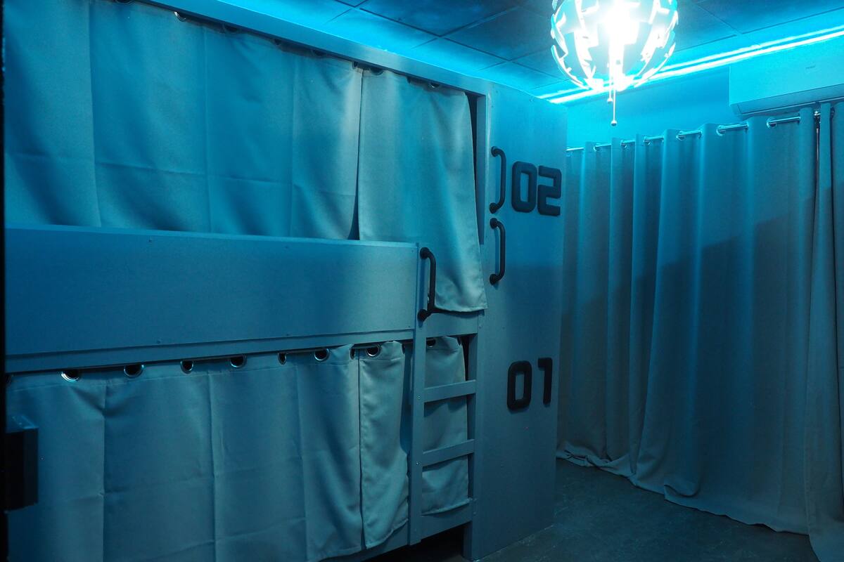 A room with bunk beds, curtains, and a unique spherical light fixture.