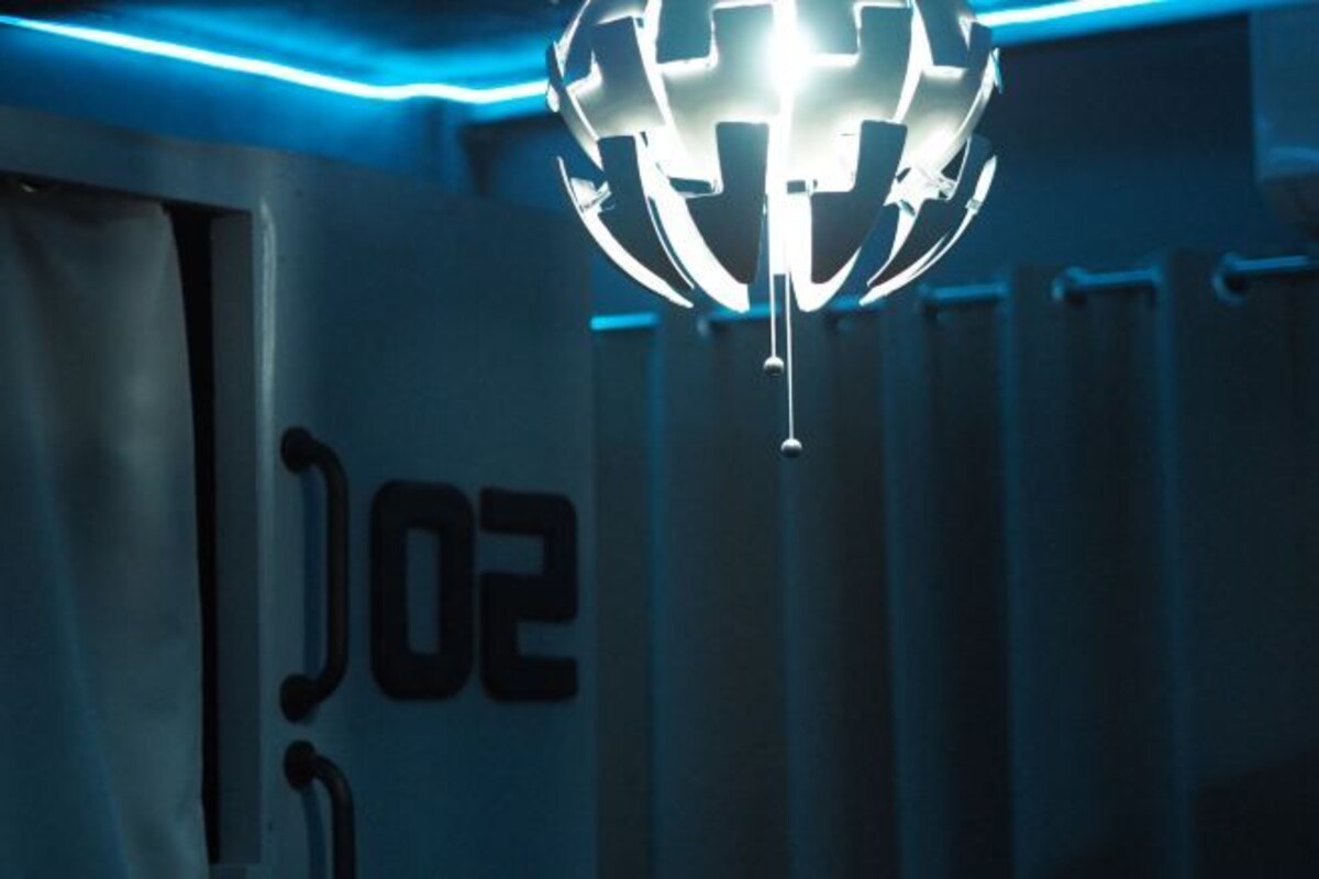 Ett rum med ett stort siffran "02" på väggen och en modern, sfärisk lampa.