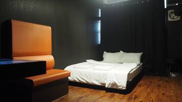 A room with a bed, a chair, and an air conditioning unit.