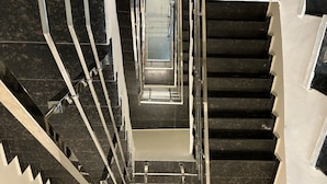 A modern staircase with metal railings and black steps. - Siswan View Hotel (Kharar)