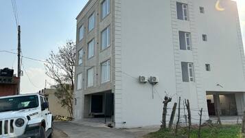 A multi-story building with a flat facade, large windows, and air conditioning units.