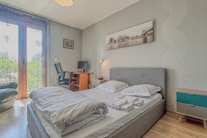 Moderni hotellihuone, jossa on suuri sänky, työpöytä ja tuoli.
