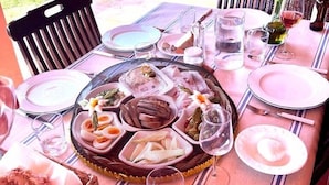 Een gedekte tafel met borden, glazen en verschillende soorten eten.