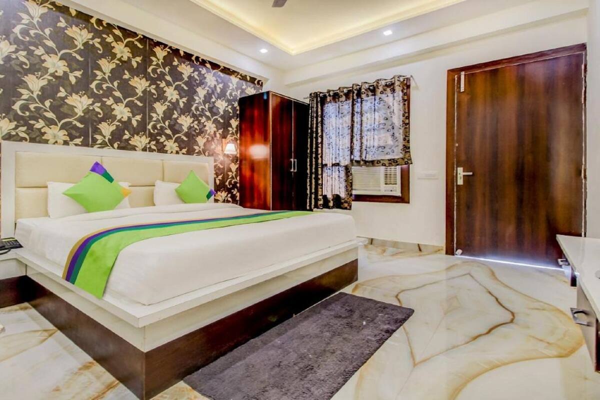 Un dormitorio con cama, mesita de noche, armario y baño.