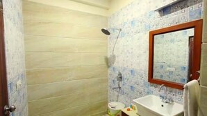 A bathroom with a shower, a sink, and a mirror. - Hotel Vedic Inn (Kiraoli)