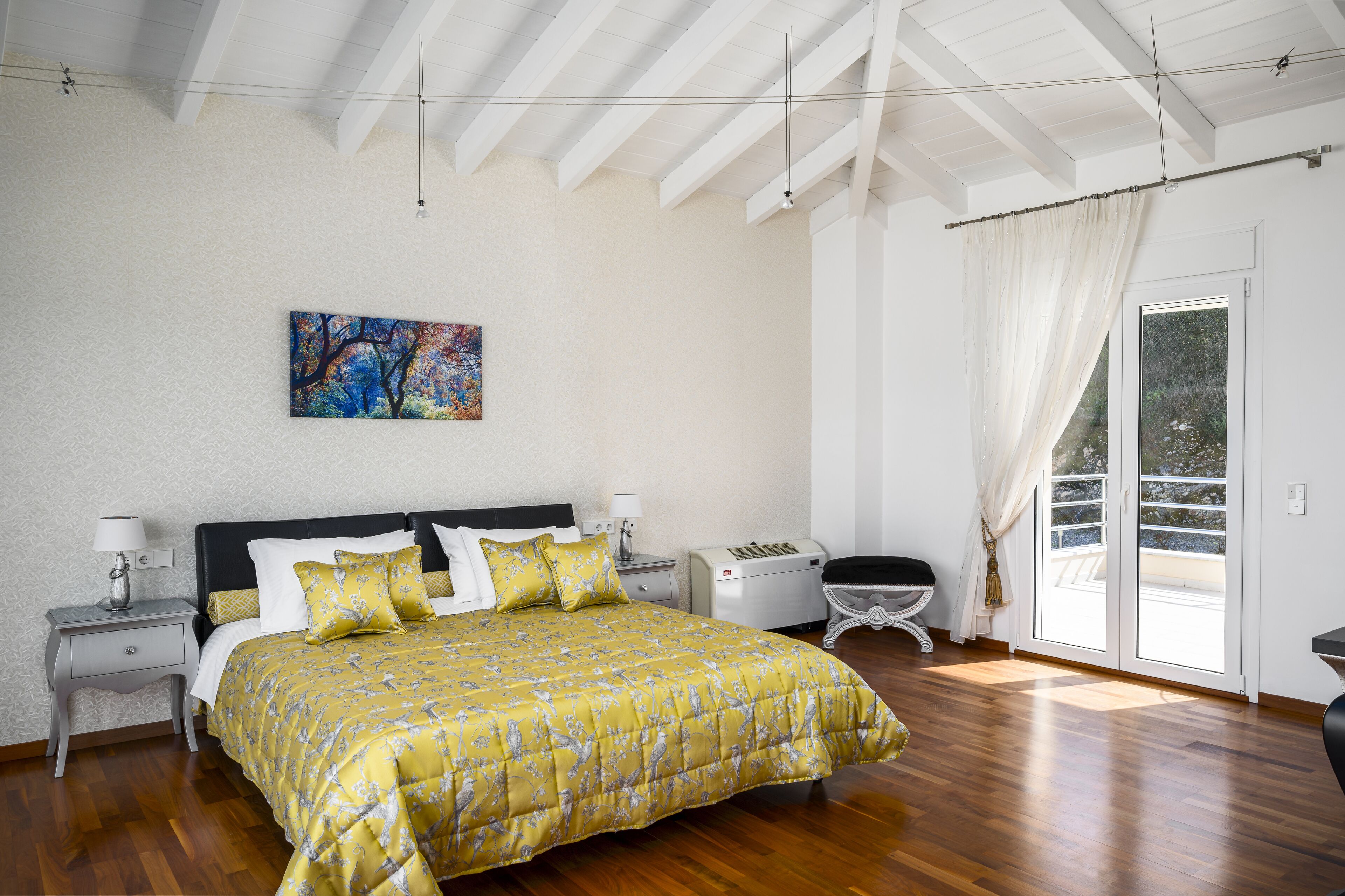 A bedroom with a bed, nightstands, a heater, a window with curtains, and a painting on the wall.