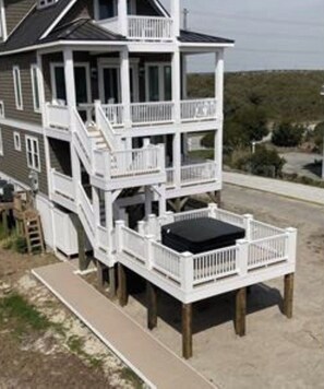 Une maison à plusieurs niveaux dotée d’un balcon et d’une petite terrasse.