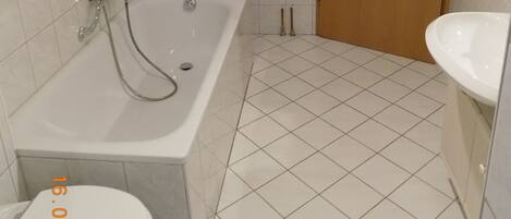 A bathroom with a bathtub, toilet, and sink.