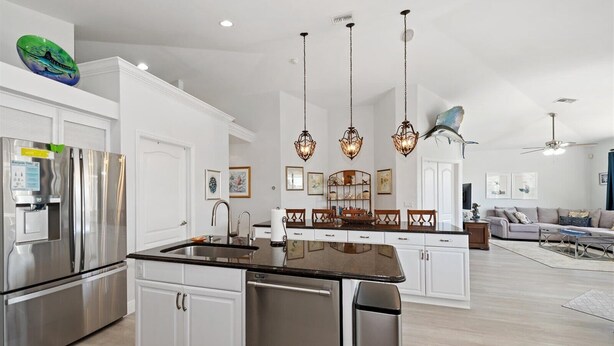 A modern kitchen with stainless steel appliances, a central island, and pendant lighting. - Seagrape Retreat - Walking distance to the beach! (Marco Island)