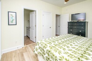 Une chambre à coucher avec un lit, une commode et un téléviseur.