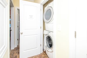 A laundry room with a door marked 'LAUNDRY ROOM' and a sign instructing to clean dryer vents after every load. - Island Life - Amazing Oceanfront 9 BR Home with Pool, Theatre Room & More! (North Topsail Beach)