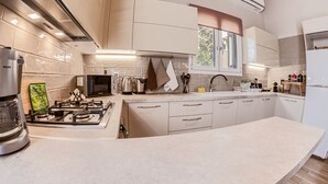 A modern kitchen with a gas stove, a built-in oven, and a large island.