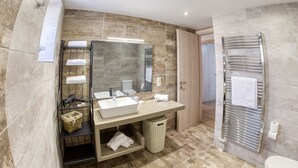A modern bathroom with a large mirror, a sink, and a towel rack.