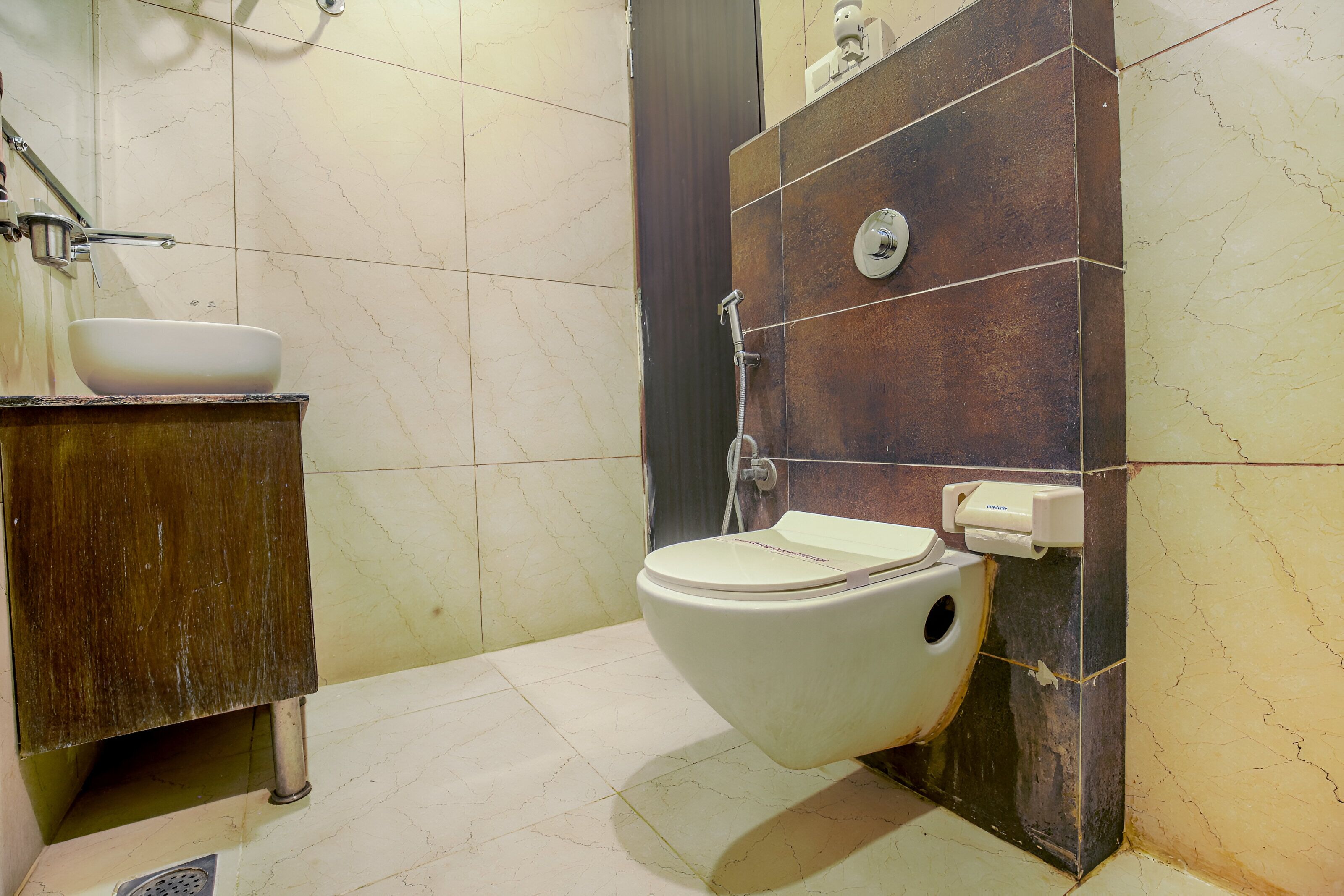 Une salle de bain avec des toilettes blanches, un lavabo avec un bac blanc et un espace douche.
