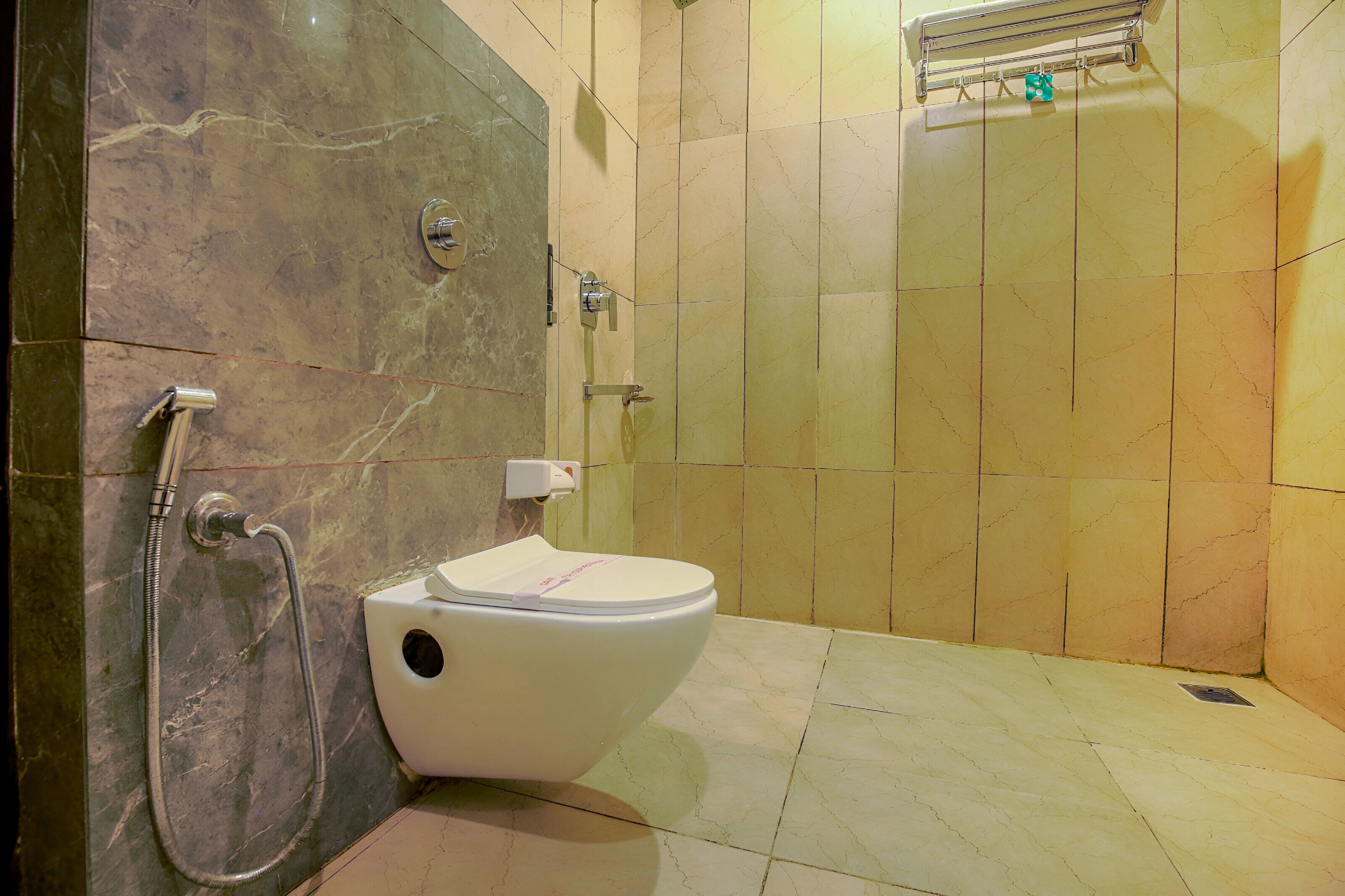 Une salle de bain équipée de toilettes, d’une douche et d’un porte-serviettes.
