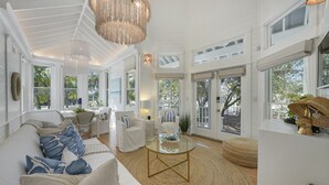 A spacious living room with a white color scheme, large windows, and a round coffee table. - Lovely Beach Home, Right Across from Beach in Seaside, Fl + 2 Adult Bikes! (Santa Rosa Beach)