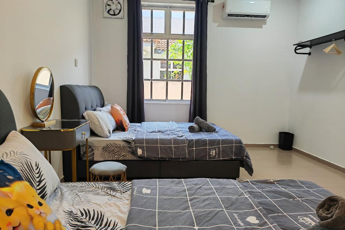 Une chambre à coucher avec un lit, une chaise, une petite table, un miroir et une fenêtre avec des rideaux.