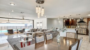 A spacious living area with a large dining table, comfortable seating, a kitchen with modern appliances, and a view of the outdoors. - 2 Mi to Golf: Poolside Paradise in Scottsdale! (Scottsdale)