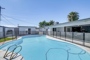 A swimming pool with a metal ladder, surrounded by a fenced area and a building with a flat roof. - 2 Mi to Golf: Poolside Paradise in Scottsdale! (Scottsdale)