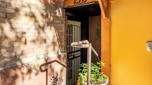 A yellow door with a "hello" sign above it, a metal gate, and a potted plant with flowers. - 2 Mi to Downtown Denver: Stylish Gem w/ Fireplace! (Denver)