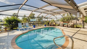 A covered outdoor swimming pool with lounge chairs and a patio area. - Port Charlotte Paradise w/ Private Outdoor Oasis! (Port Charlotte)