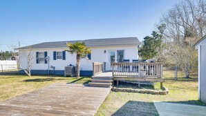 A single-story house with a wooden deck leading to a front porch. - Pet-friendly Beaufort Home w/ Private Yard (Beaufort)