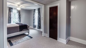 A bedroom with a bed, a ceiling fan, and a door. - Family-friendly Altoona Abode w/ Spacious Patio! (Altoona)