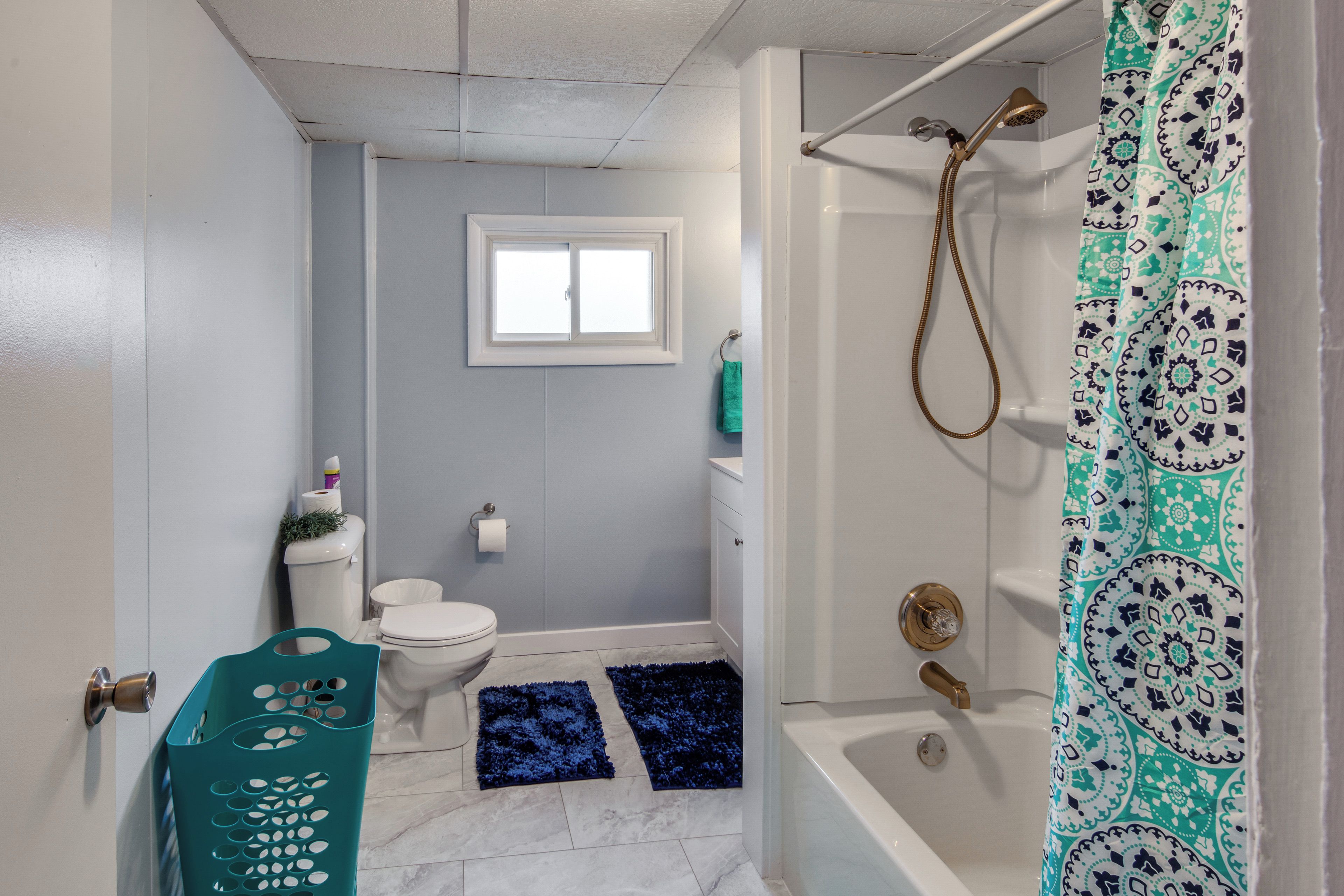 Une salle de bain avec des toilettes, une douche et une fenêtre.