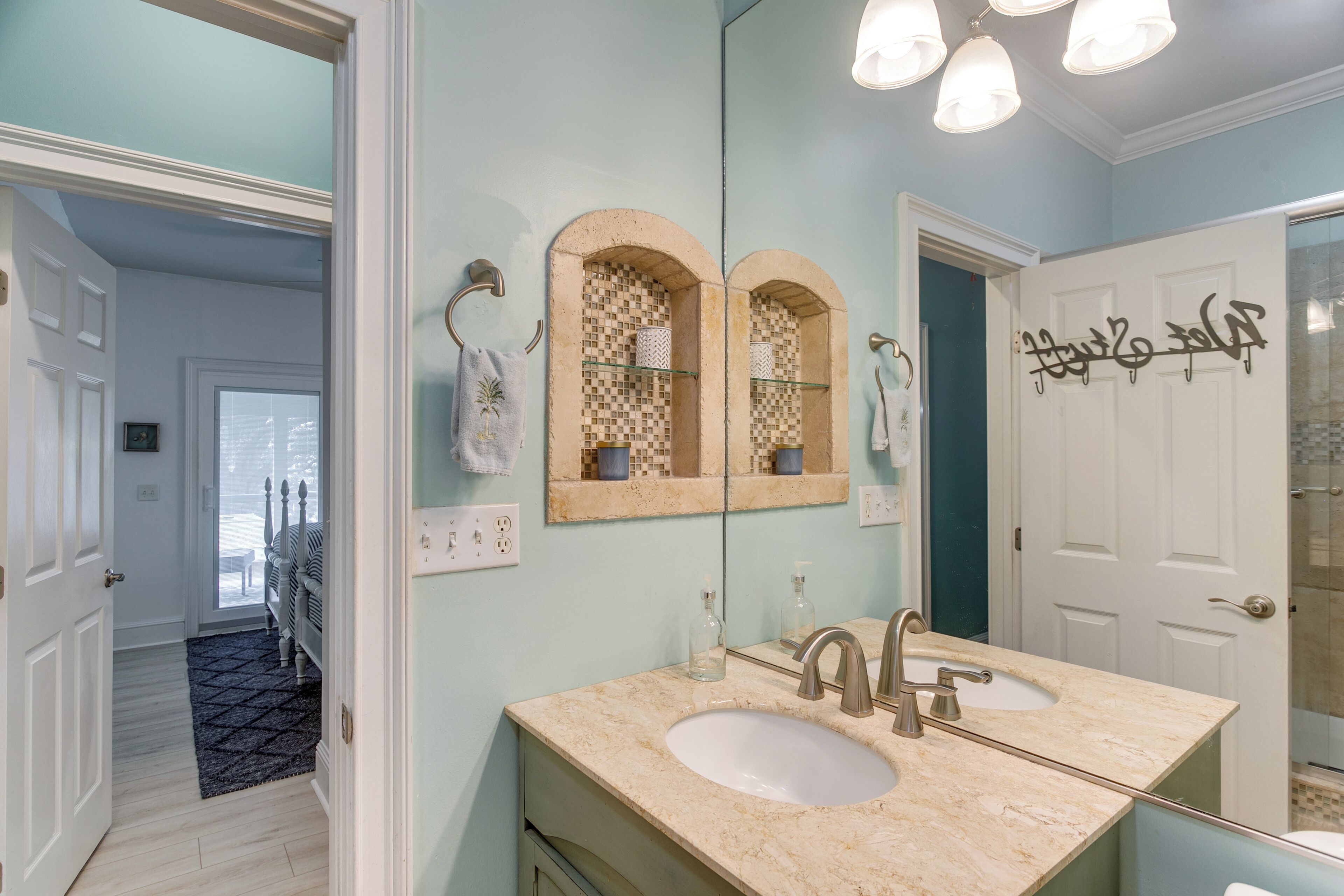A bathroom with a large mirror, two sinks, and a shower.