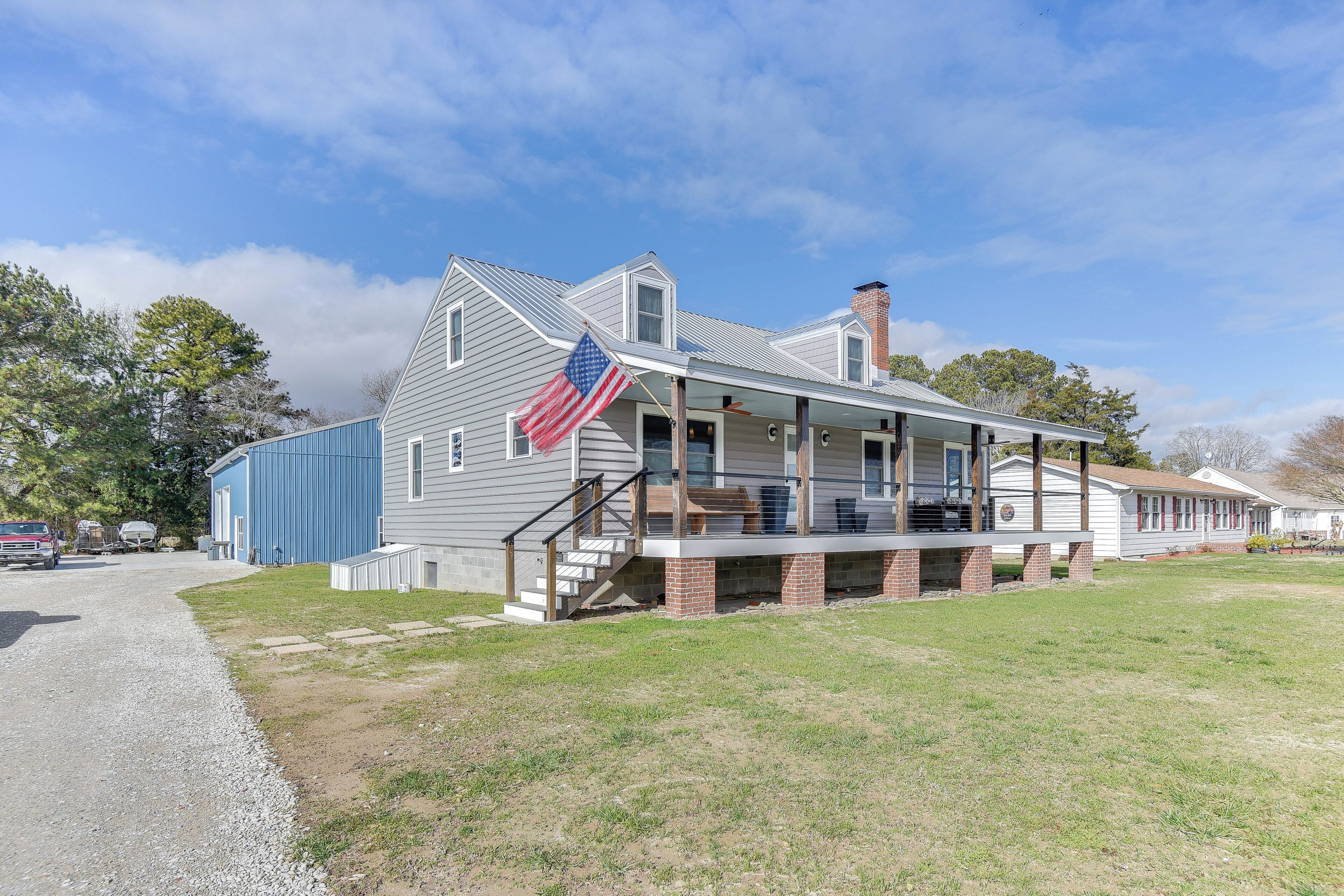 A two-story house with a porch and an American flag.