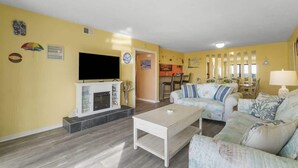 A living room with a flat-screen TV, a fireplace, two sofas, and a coffee table. - Moondrifter 207 - Condo with Spectacular Views (Panama City Beach)
