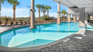 A swimming pool with lounge chairs and palm trees.