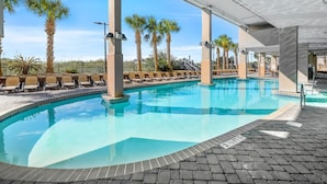 A swimming pool with lounge chairs and palm trees.